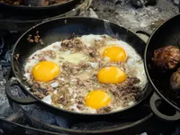 Eggs cooking in a cast-iron pan