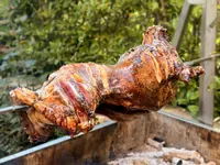 Whole lamb roasting on a spit outdoors