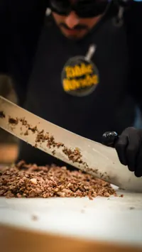 Chef chopping meat at a live station