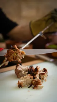 Chef cutting cooked meat for serving