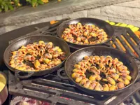 Three pans cooking on the outdoor grill