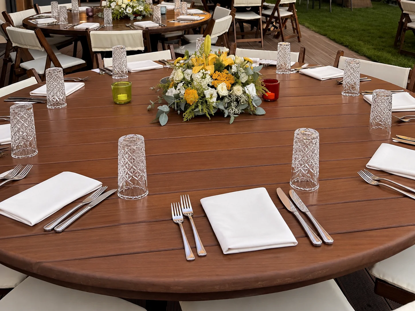 Outdoor dining table set with flowers and glassware