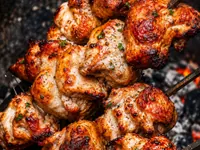 Tandoori chicken roasting over coals
